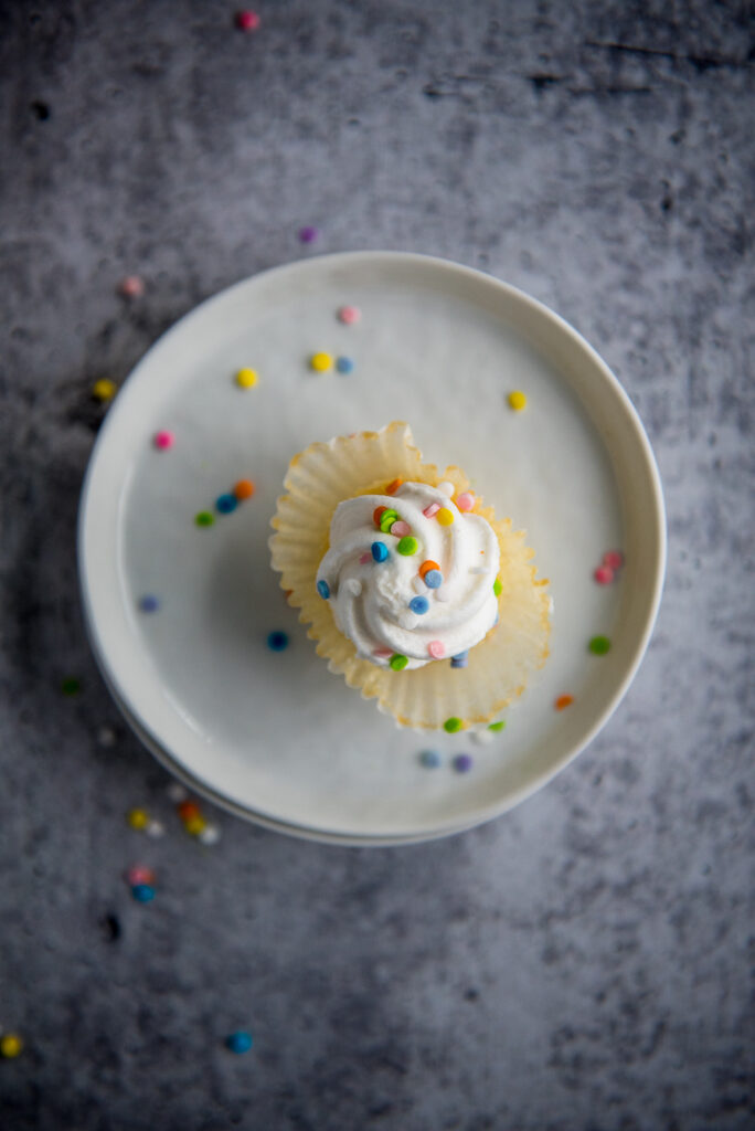 Overhead photo of mini cupcake and sprinkles, shot by food photographer Rebecca Hales