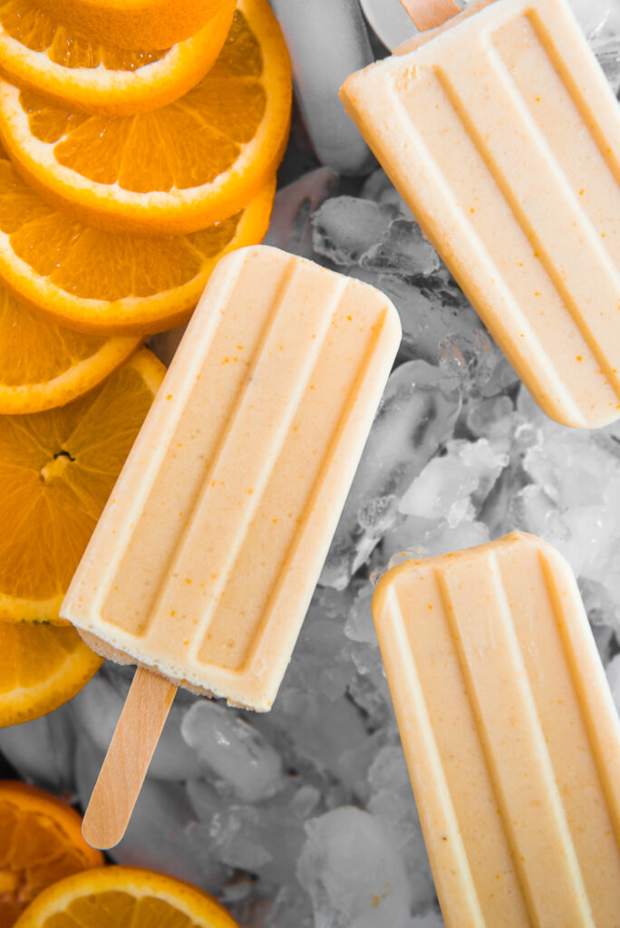Orange cream popsicles, shot by food photographer Rebecca Hales