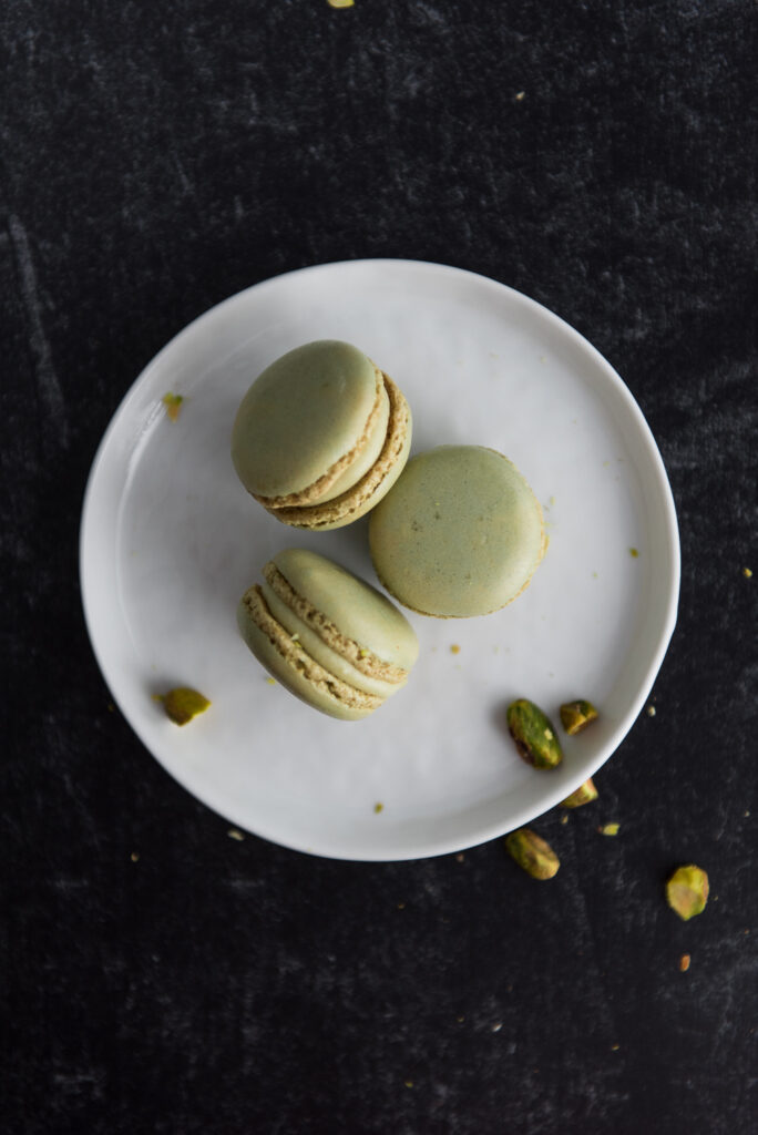 Pistachio Macarons with pistachio garnish, shot by food photographer Rebecca Hales